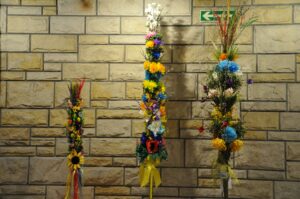 3 palmy wykonane z kolorowych materiałów: bibuły, suszonych kwiatów i gałązek