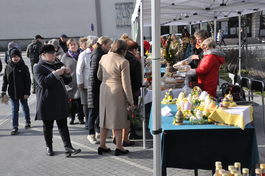 Tłum ludzi przy kolorowych, wiosennych stoiskach. Słoneczny dzień.
