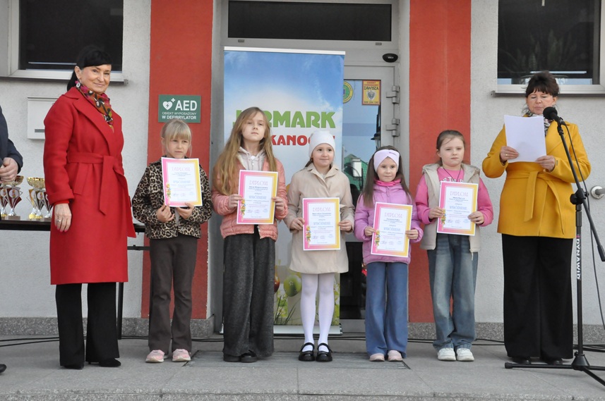 Dwie kobiety i pięć dziewczynek pozują do wspólnego zdjęcia. Dziewczynki trzymają dyplomy.